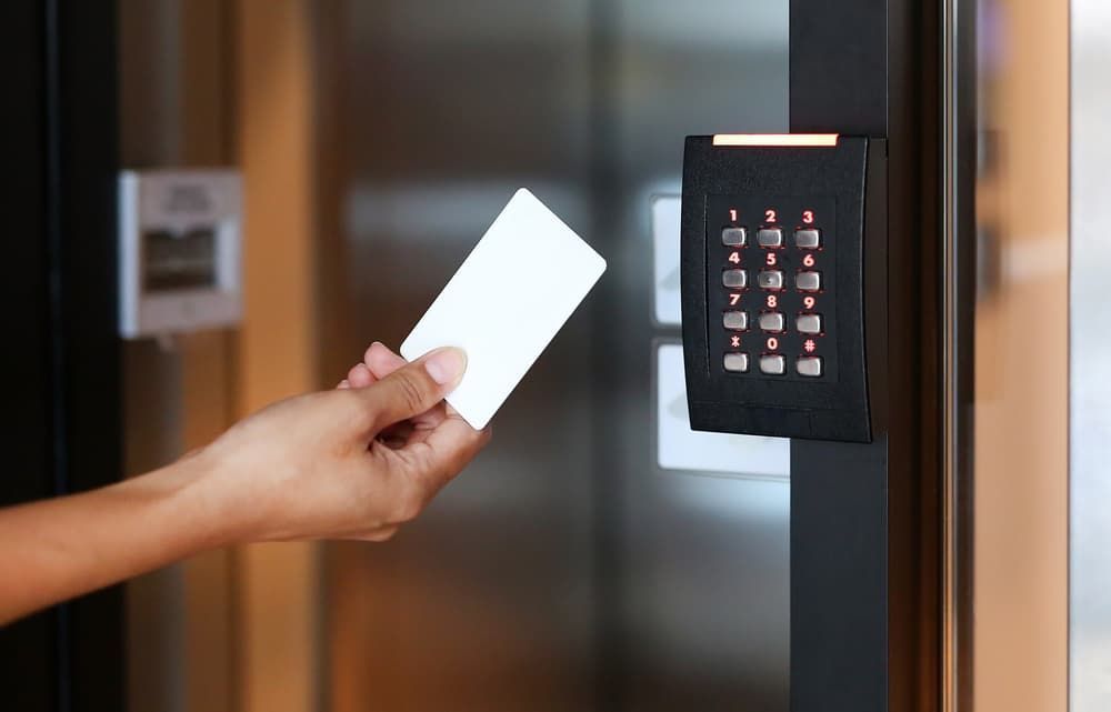 A Person is Holding a Card in Front of a Door — Coast & Hinterland Mobile Locksmiths In Noosaville, QLD
