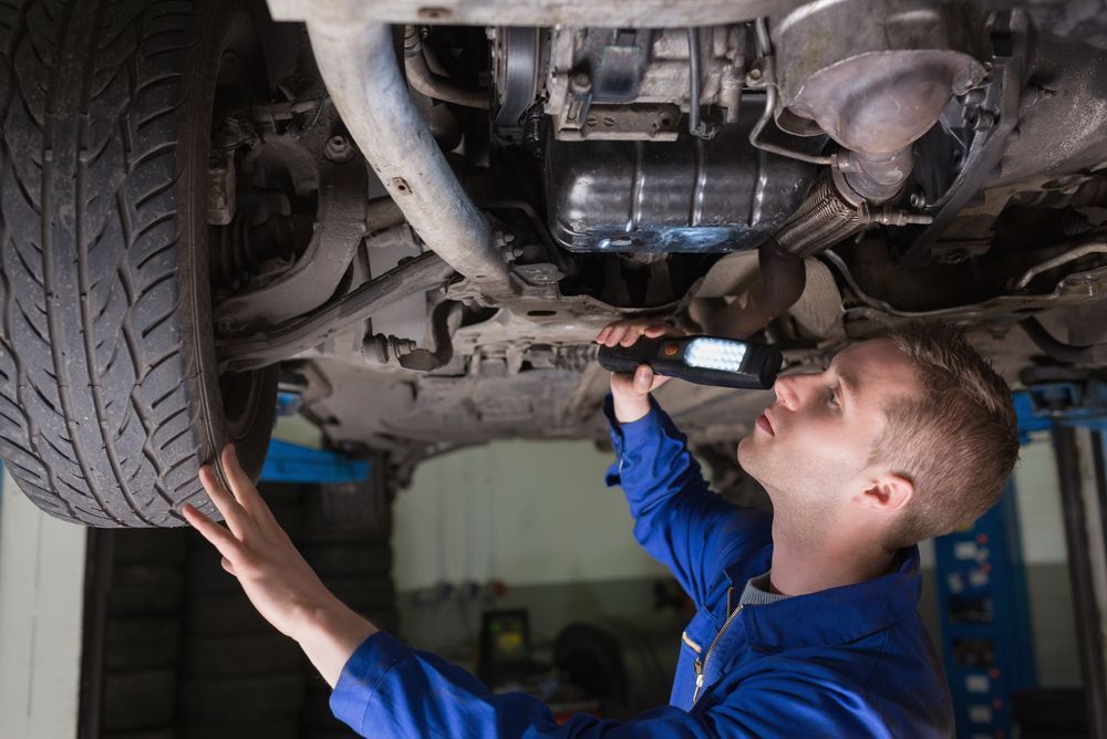 Mechanic Inspecting Car Undercarriage — CE Automotive Service Centre in Garbutt, QLD