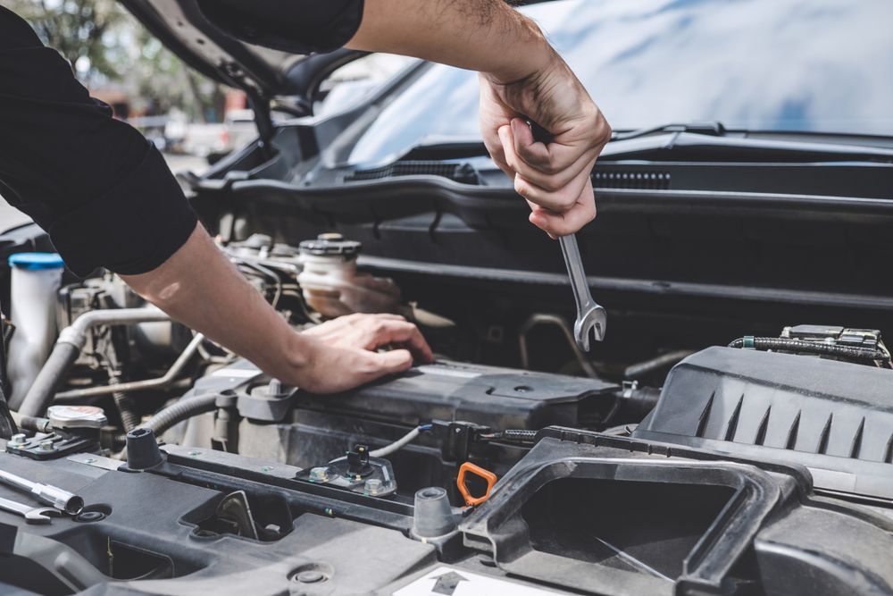 Hands of a Mechanic Working on a Car Engine With a Wrench — CE Automotive Service Centre in Garbutt, QLD