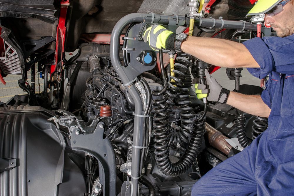 Mechanic Working on a Truck Engine, Wearing Safety Gloves — CE Automotive Service Centre in Garbutt, QLD