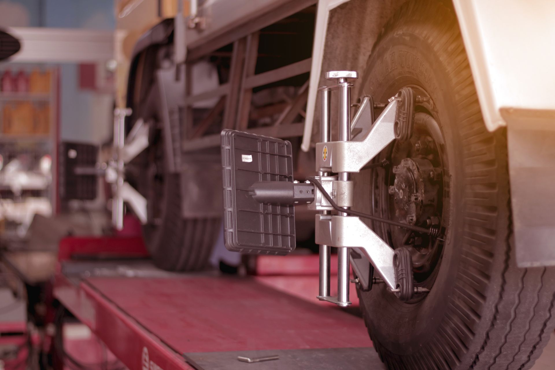 Truck Wheel Being Aligned on a Lift in a Repair Shop — CE Automotive Service Centre in Garbutt, QLD