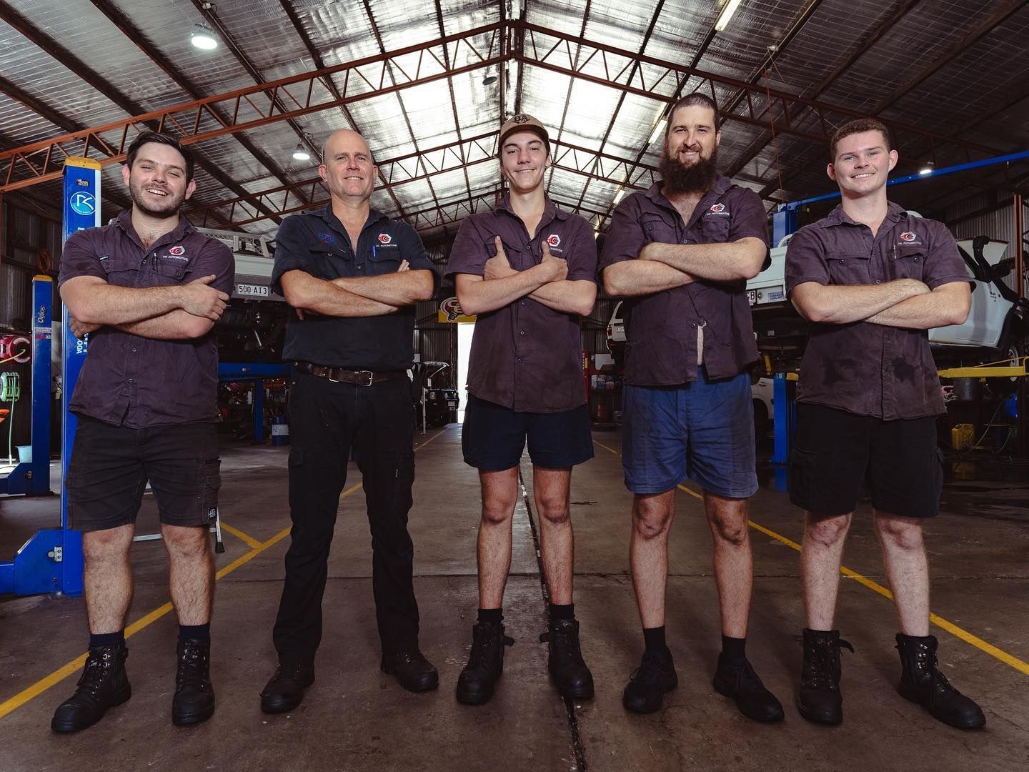Five Mechanics in Work Shirts and Shorts, Arms Crossed — CE Automotive Service Centre in Garbutt, QLD