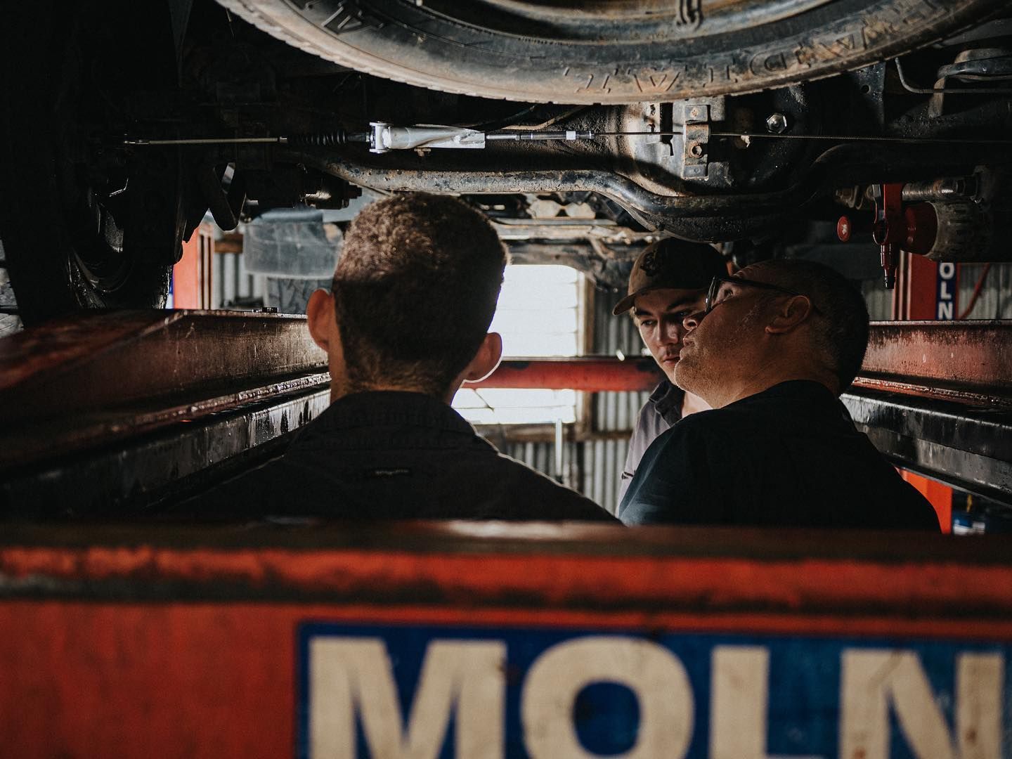Three People Examining the Undercarriage — CE Automotive Service Centre in Garbutt, QLD