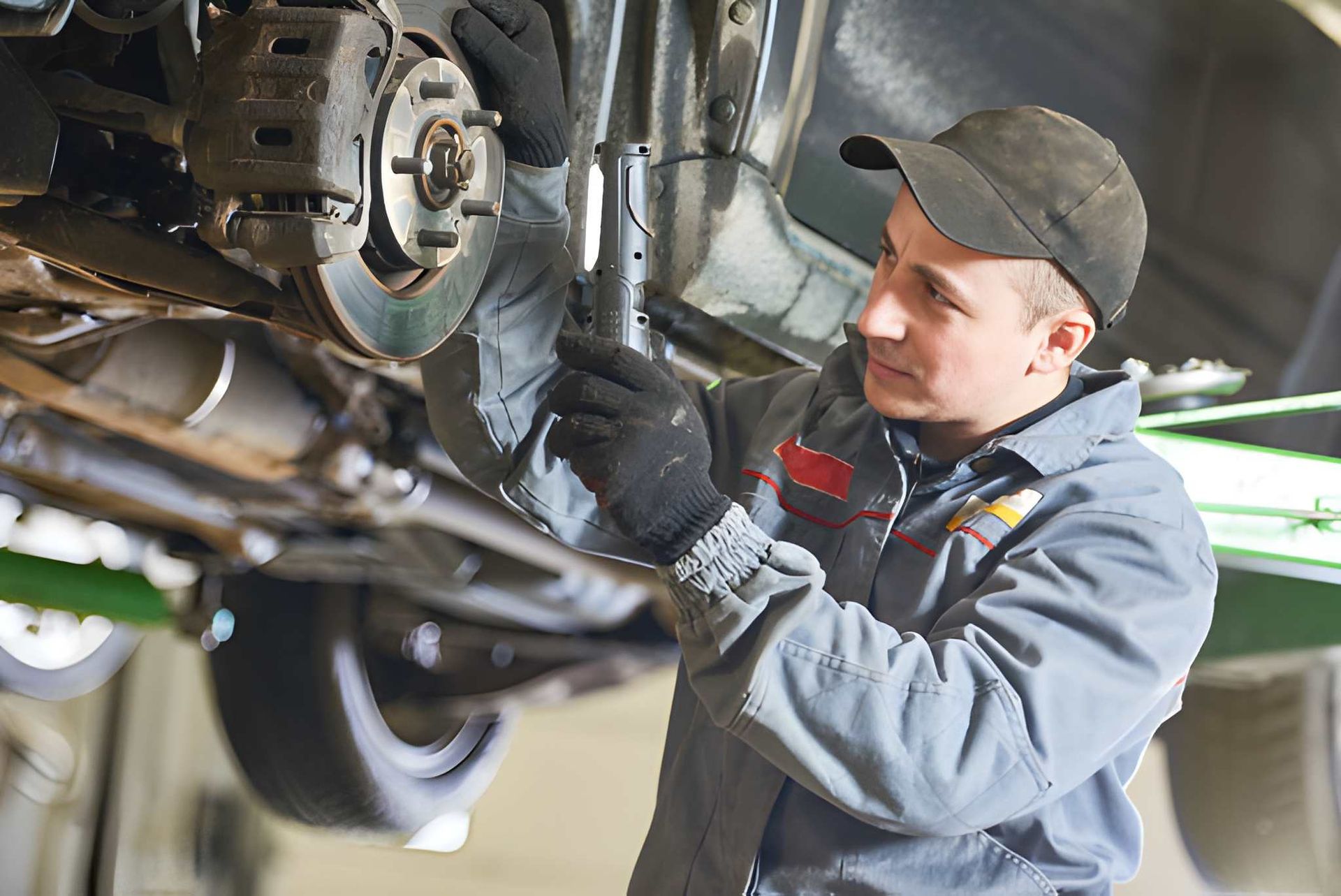 Mechanic Working on a Car's Brakes, Using a Flashlight — CE Automotive Service Centre in Garbutt, QLD
