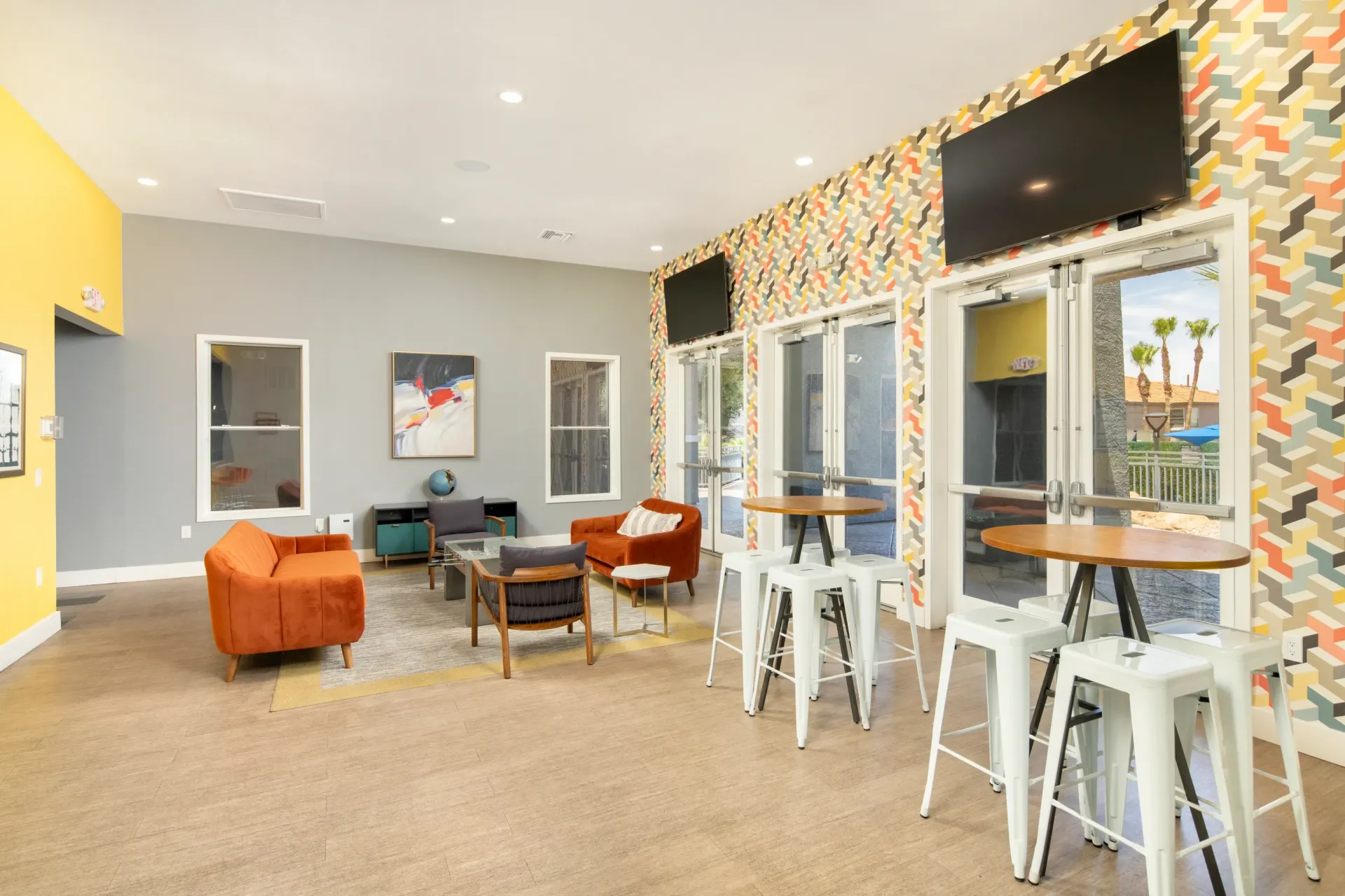 Modern lounge area with colorful accent wall, seating, and high-top tables at Sonoran Reserve in Tucson, AZ.