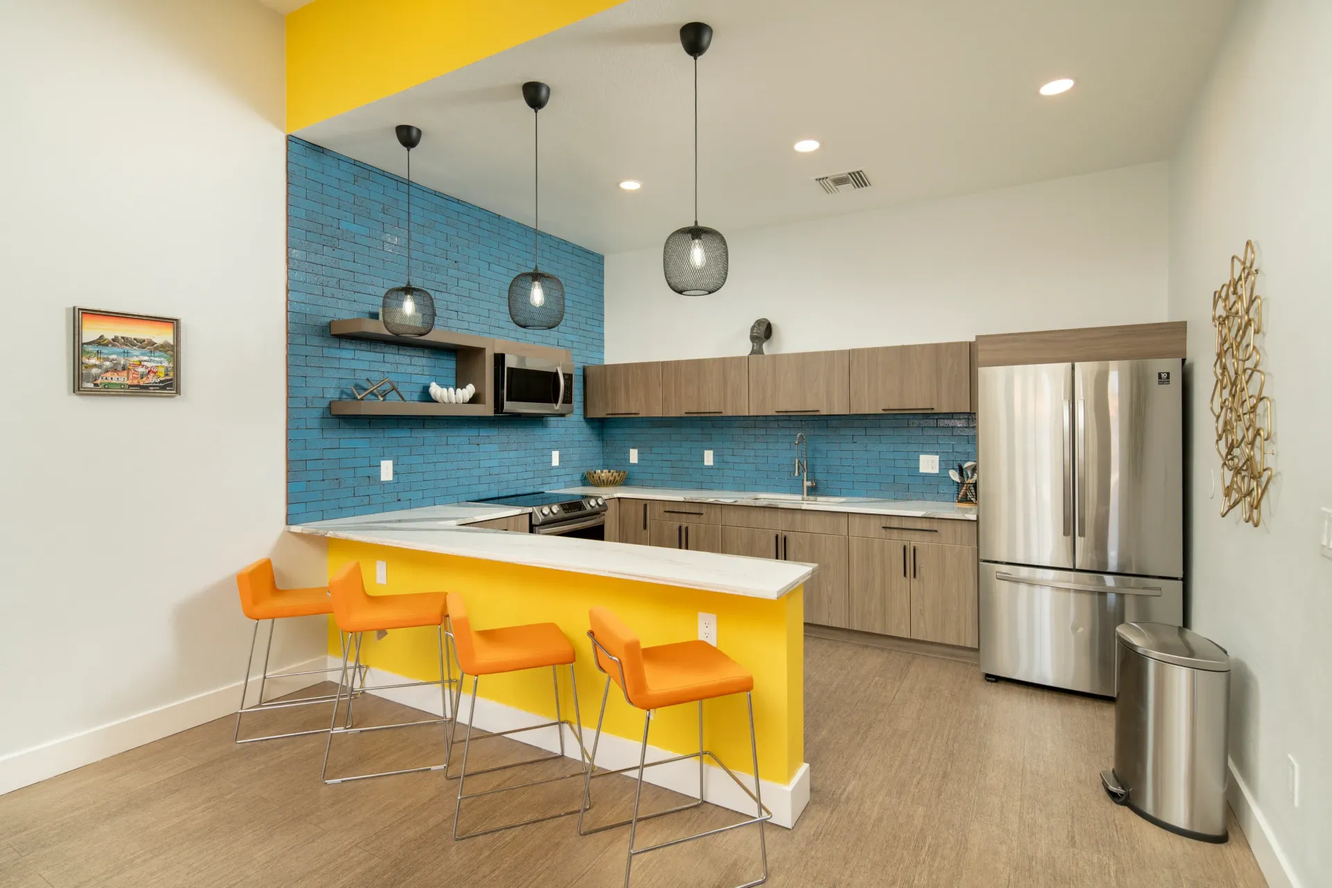 Modern kitchen with blue brick backsplash, stainless steel appliances, and island seating at Sonoran Reserve in Tucson, AZ.