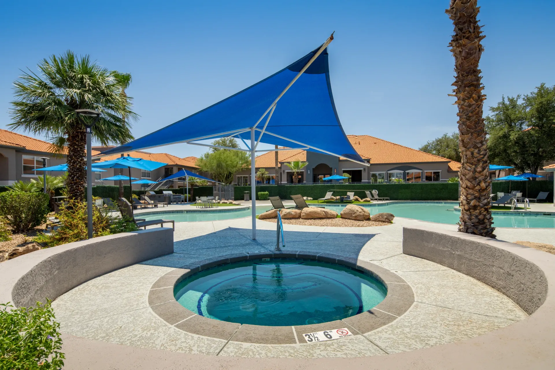 Outdoor swimming pool and hot tub area with lounge chairs and umbrellas at Sonoran Reserve in Tucson, AZ.