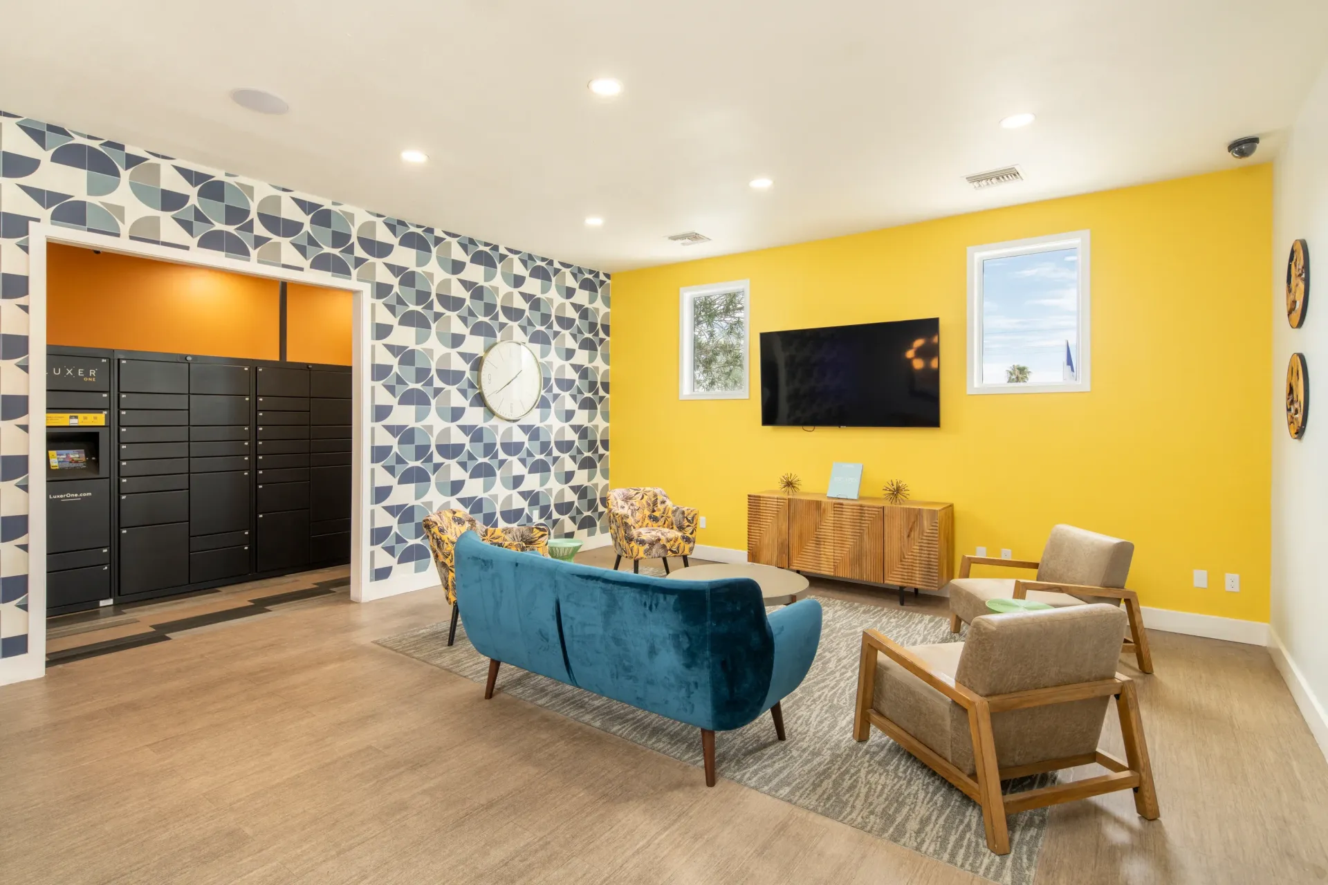 Lobby with Luxer One package lockers, a blue sofa, and accent chairs at Sonoran Reserve in Tucson, AZ.