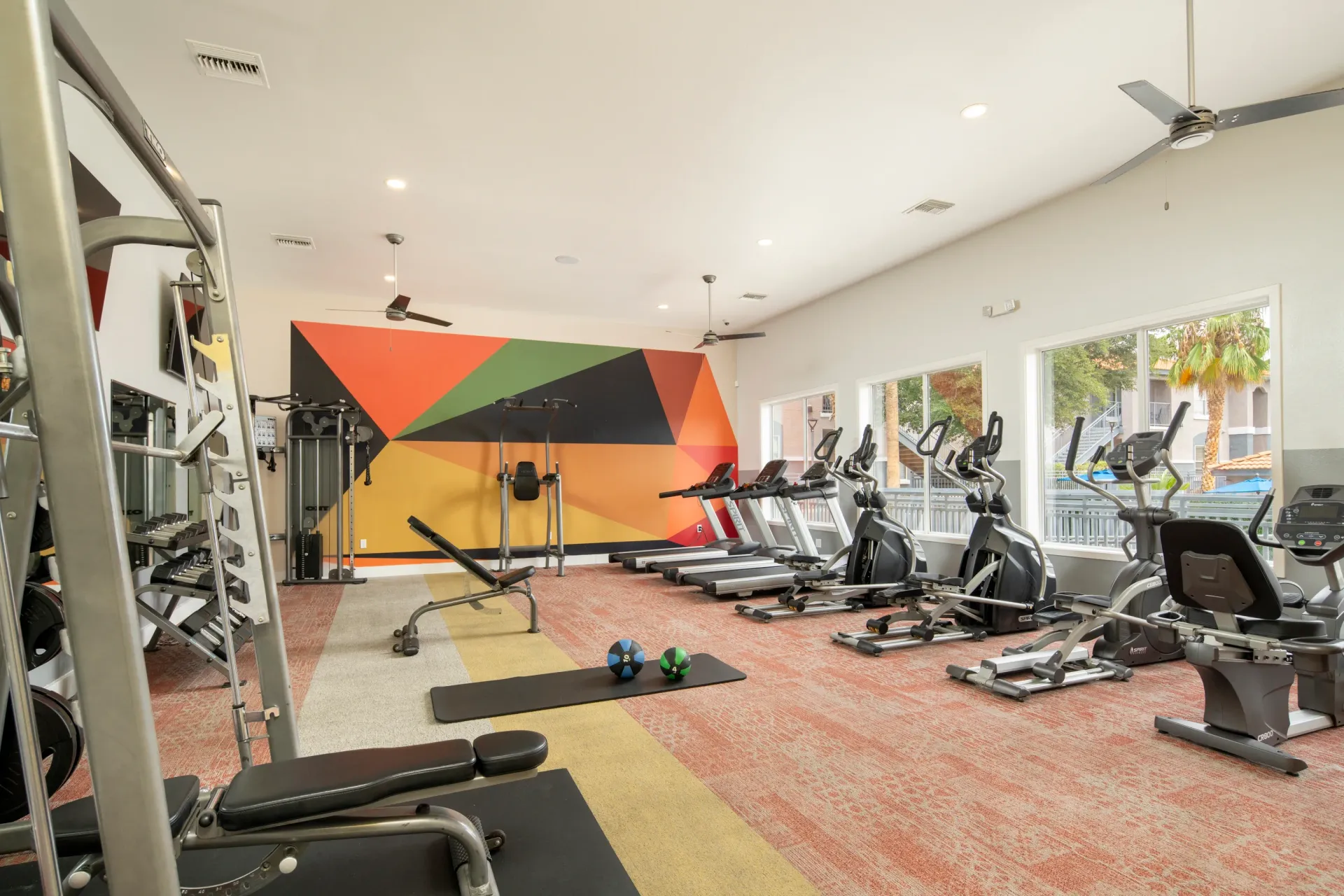 Fitness center with treadmills, ellipticals, weight machines, and free weights.