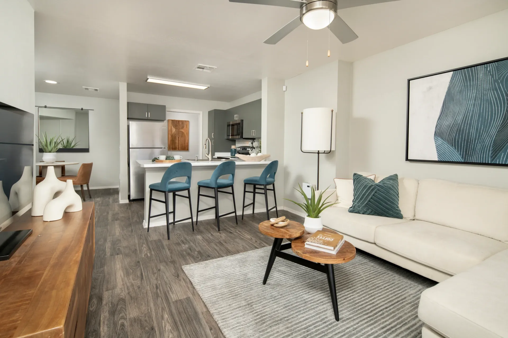 Living room and kitchen area with island seating, sofa, coffee table, and dining area at Sonoran Reserve in Tucson, AZ.