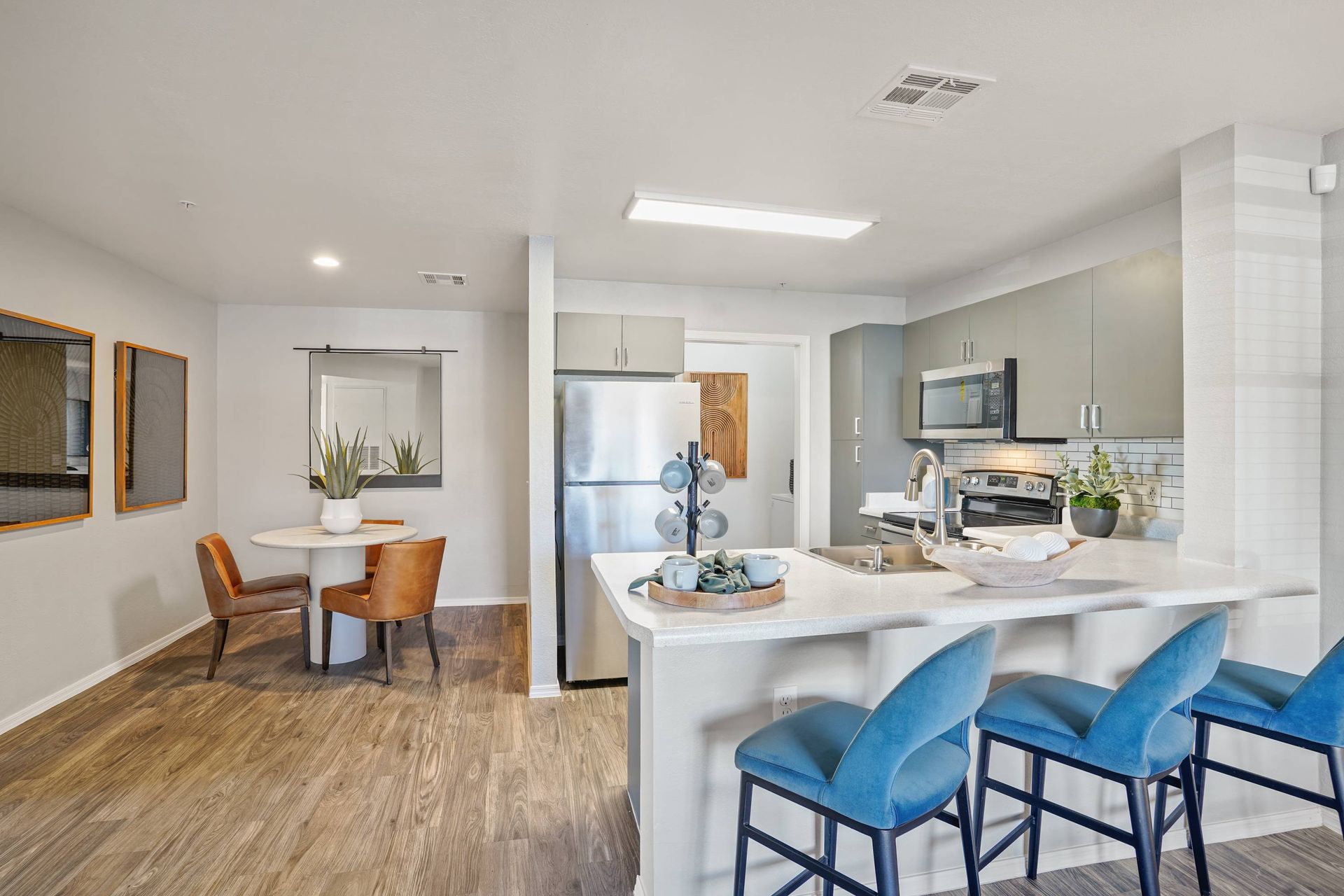 Open-concept apartment kitchen with island, stainless steel appliances, and a small dining area.  Visit Sonoran Reserve and explore spacious 2-bedroom apartments in Tucson, AZ designed for modern living.
