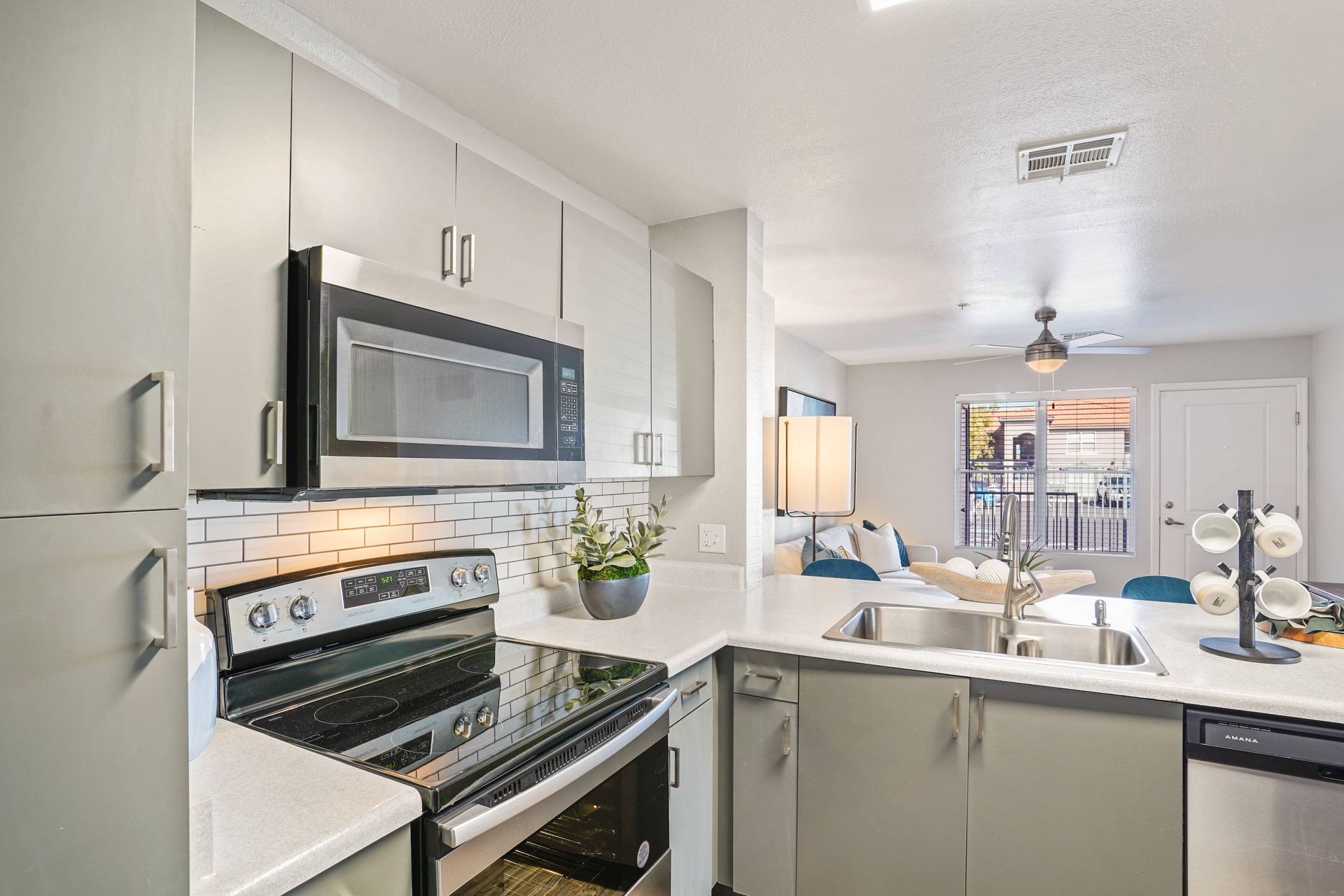 Modern kitchen with stainless steel appliances and an open living area.  Discover the perfect balance of style and function when you tour our 1-bedroom apartments in Tucson, AZ.

