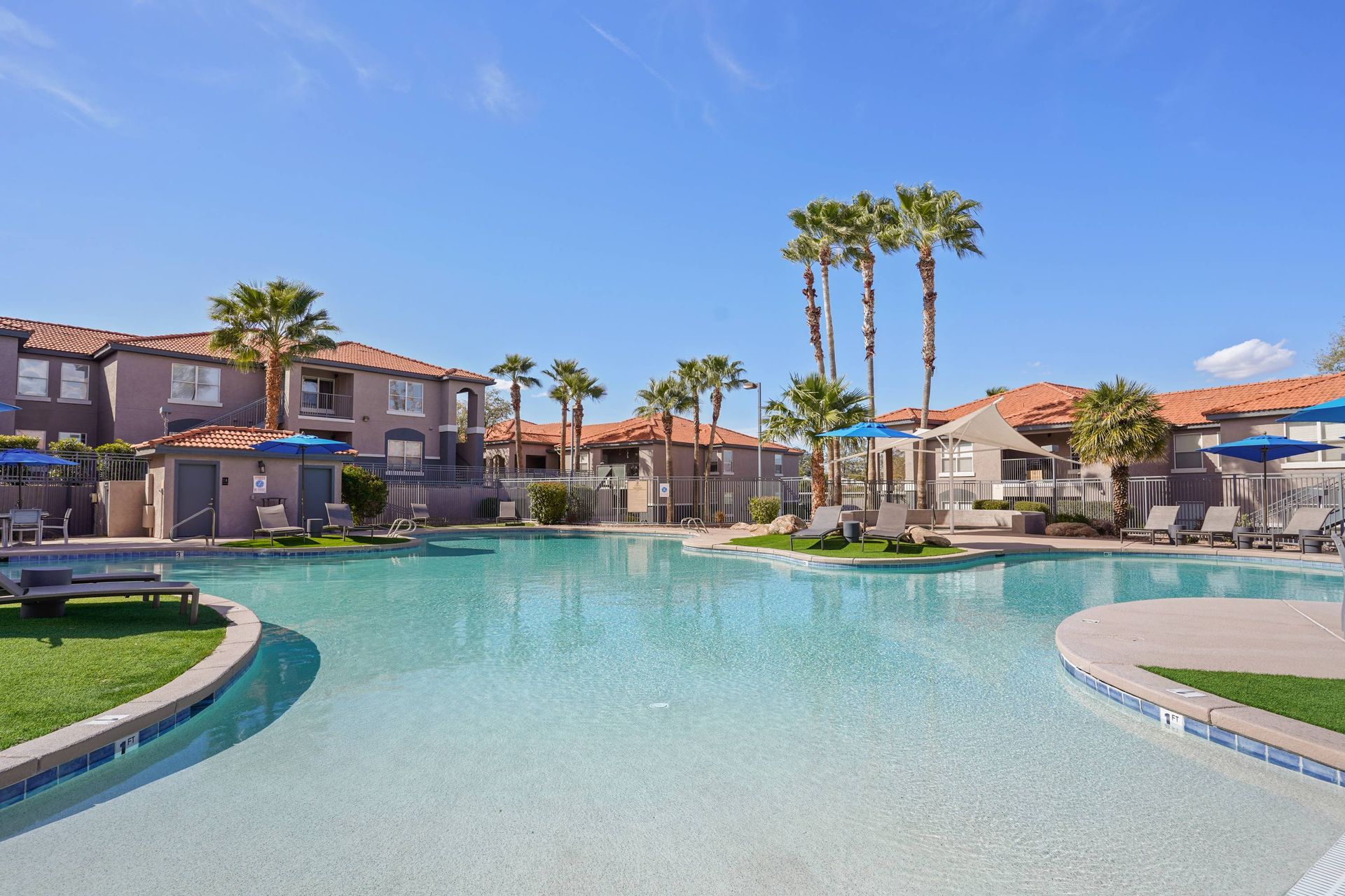 Outdoor apartment community pool with palm trees, lounge chairs, and umbrellas. See for yourself why residents love calling Sonoran Reserve home—tour our welcoming Tucson, AZ apts today.