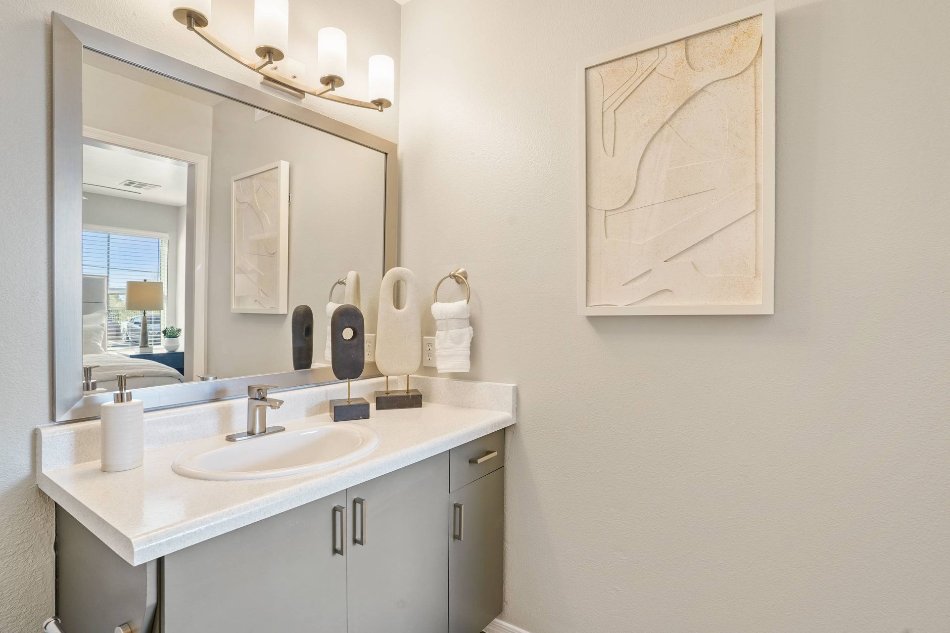 Bathroom vanity with sink, countertop, large mirror, and decorative accessories.  Schedule a tour of Sonoran Reserve and explore comfortable apts in Tucson, AZ designed for everyday living.
