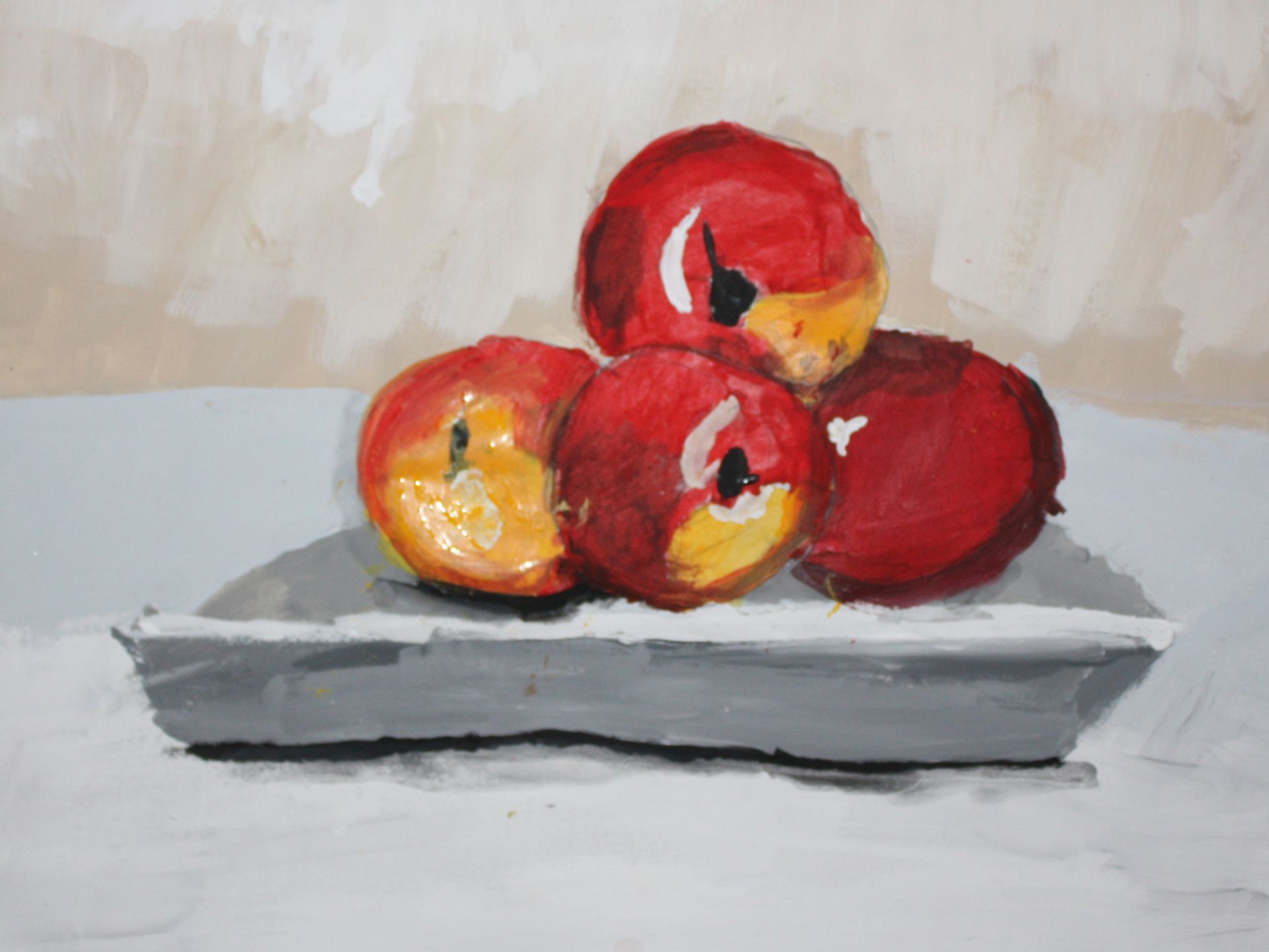 Red apples stacked on a gray plate against a light background.