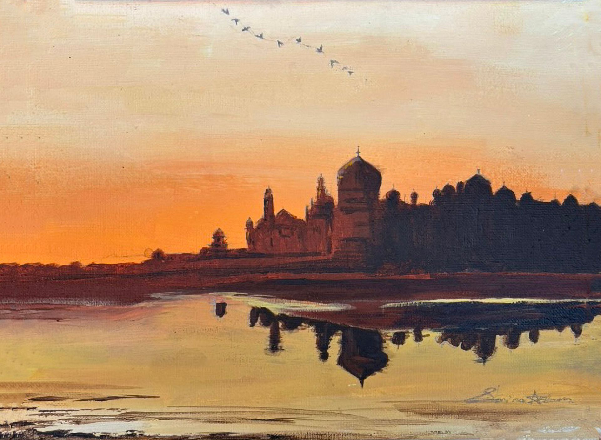 Sunset view of the Taj Mahal silhouetted against an orange sky, reflected in calm water