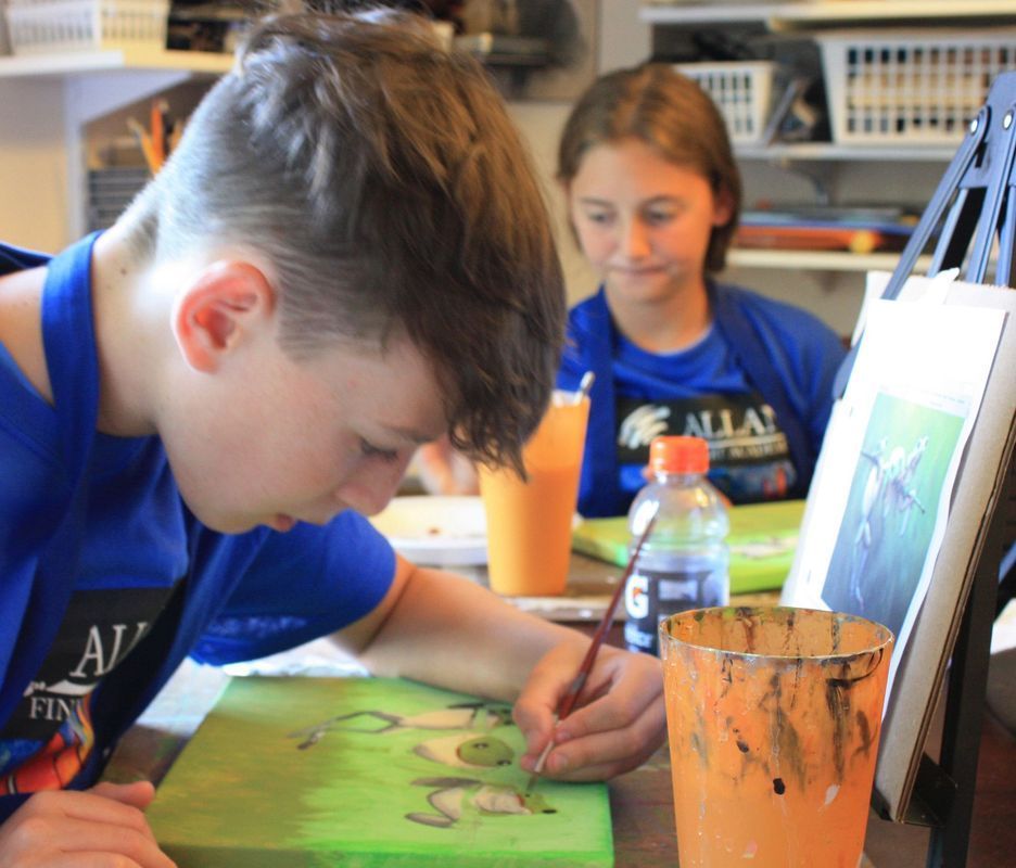 Children painting at a table with bright orange cups in a classroom or art room