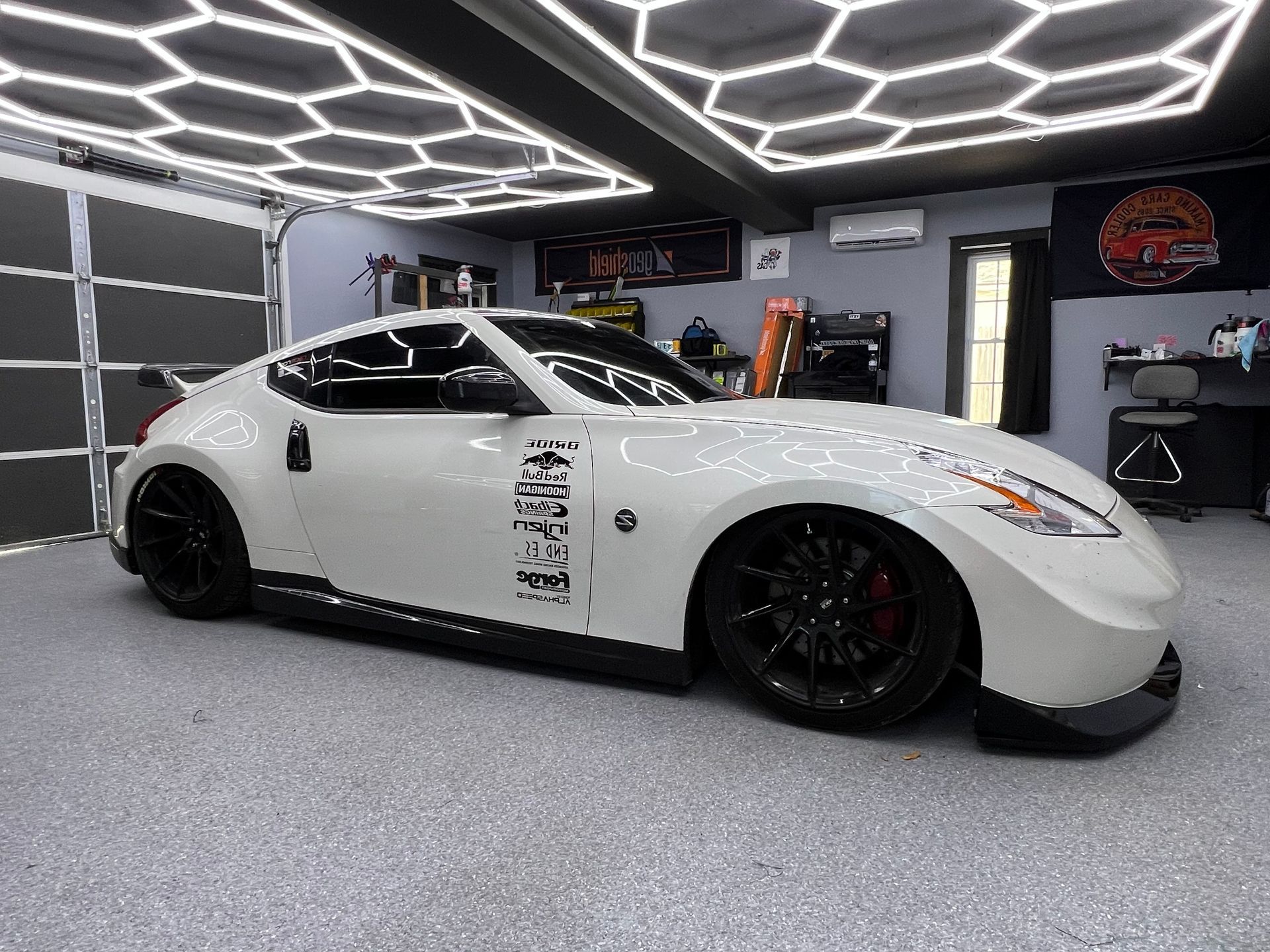 A white sports car is parked in a garage.