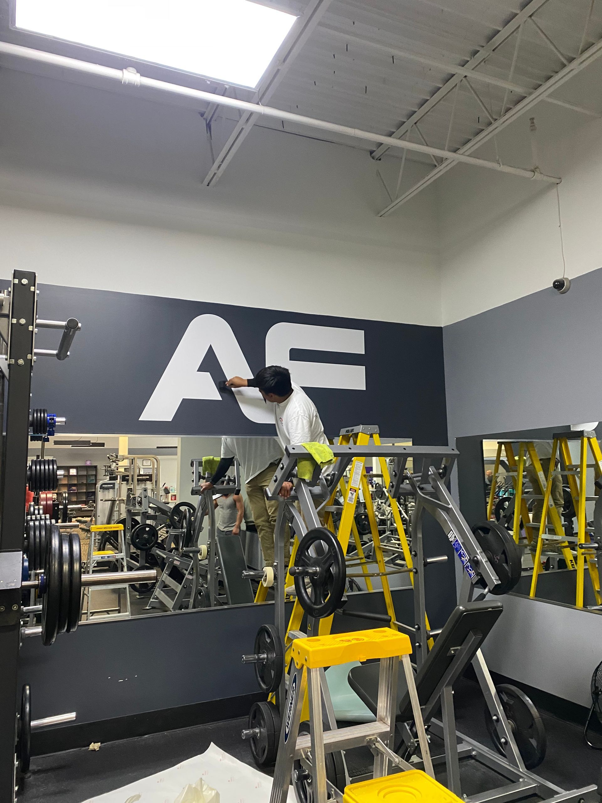 A man is working on a sign in a gym