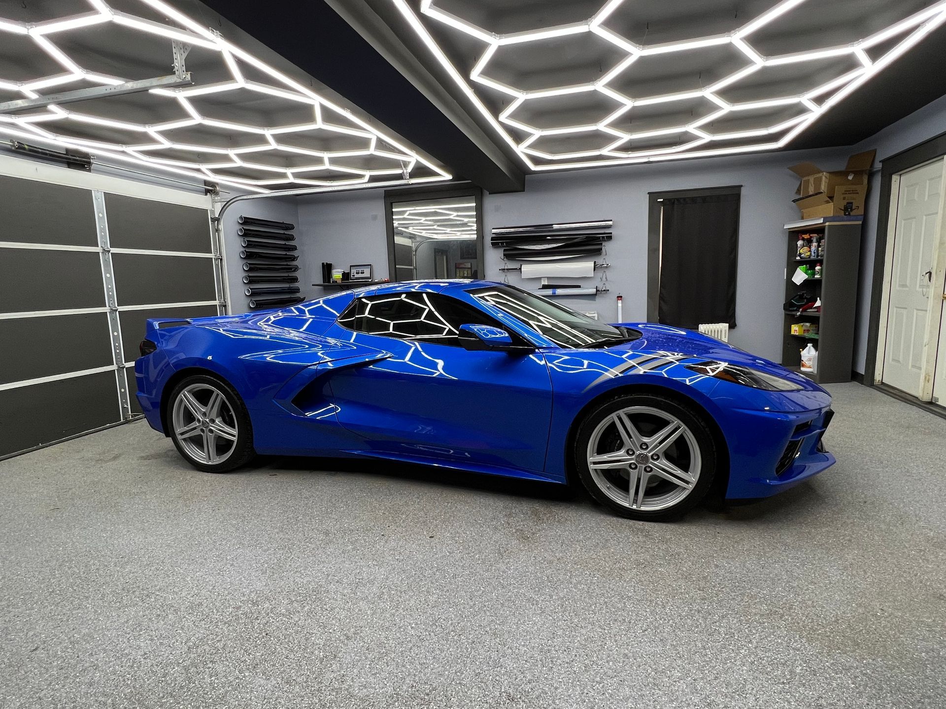 A blue sports car is parked in a garage.