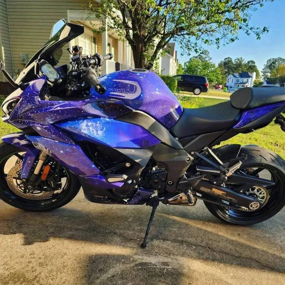 Motorcycle with a galaxy-themed paint job parked on a driveway.