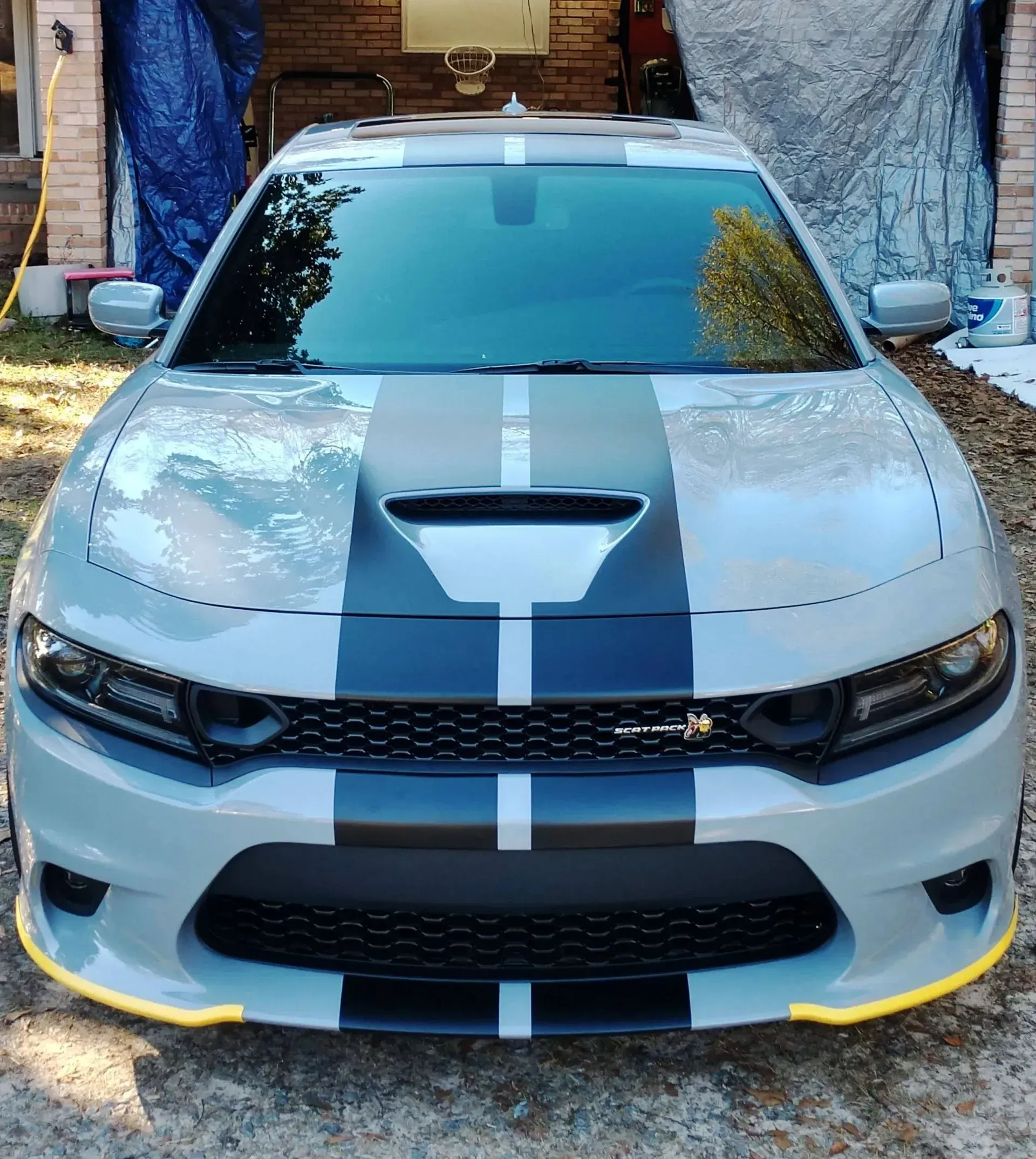 Light gray Dodge Charger with black racing stripes and yellow accents.