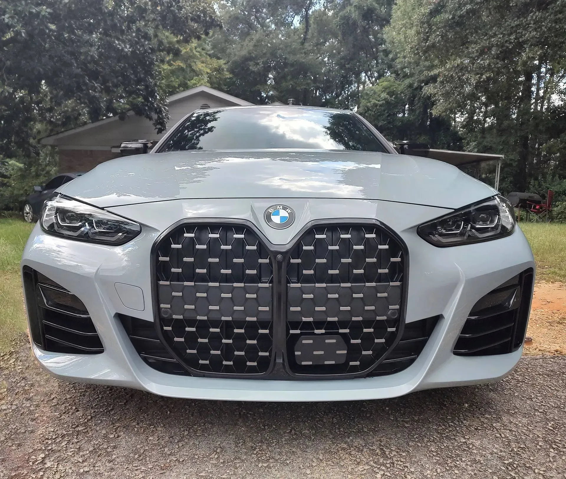 Gray BMW car with large black grille, parked outdoors.