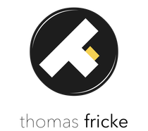 Ein Logo für Thomas Fricke mit einem „at“ im Kreis