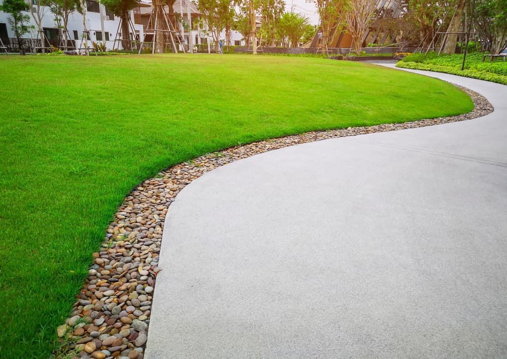 A Concrete Walkway Leading to A Lush Green Field in A Park — Green Vision NT in Virginia, NT