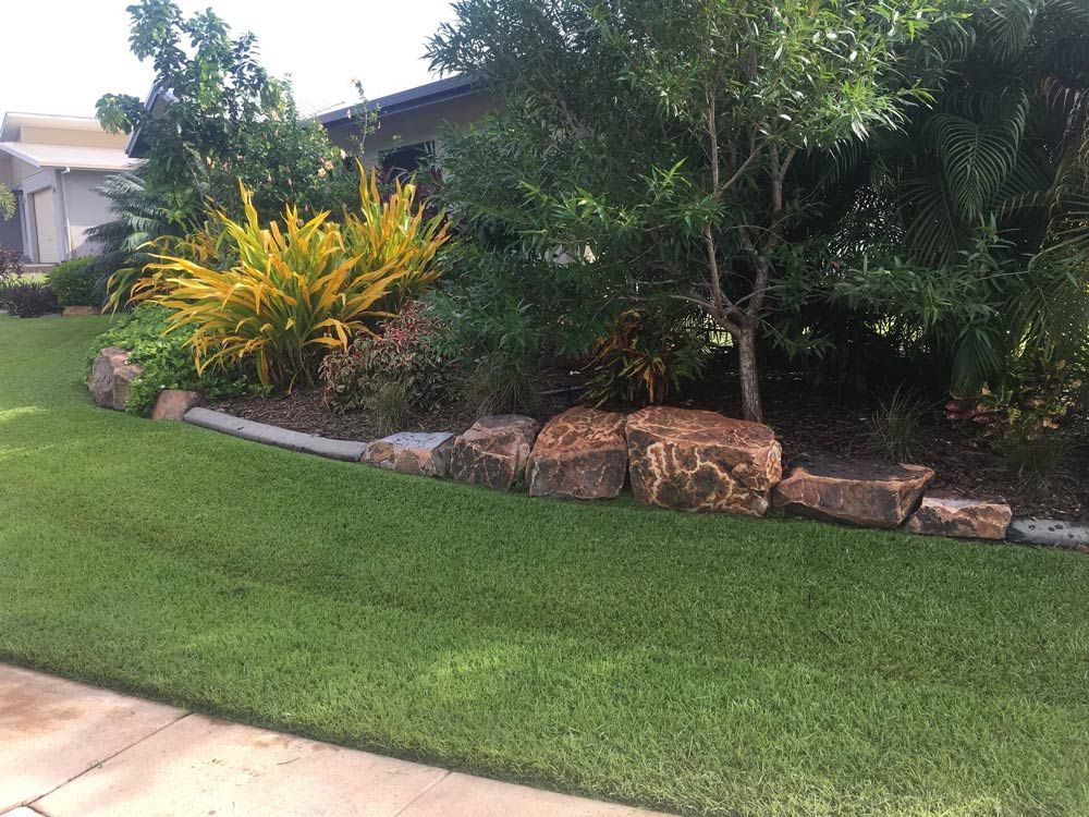 A Lush Green Lawn with Rocks and Trees in Front of A House — Green Vision NT in Virginia, NT