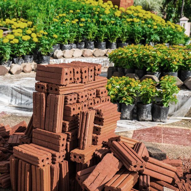 A Pile of Bricks Is Sitting in Front of A Garden Filled with Potted Plants — Green Vision NT in Virginia, NT