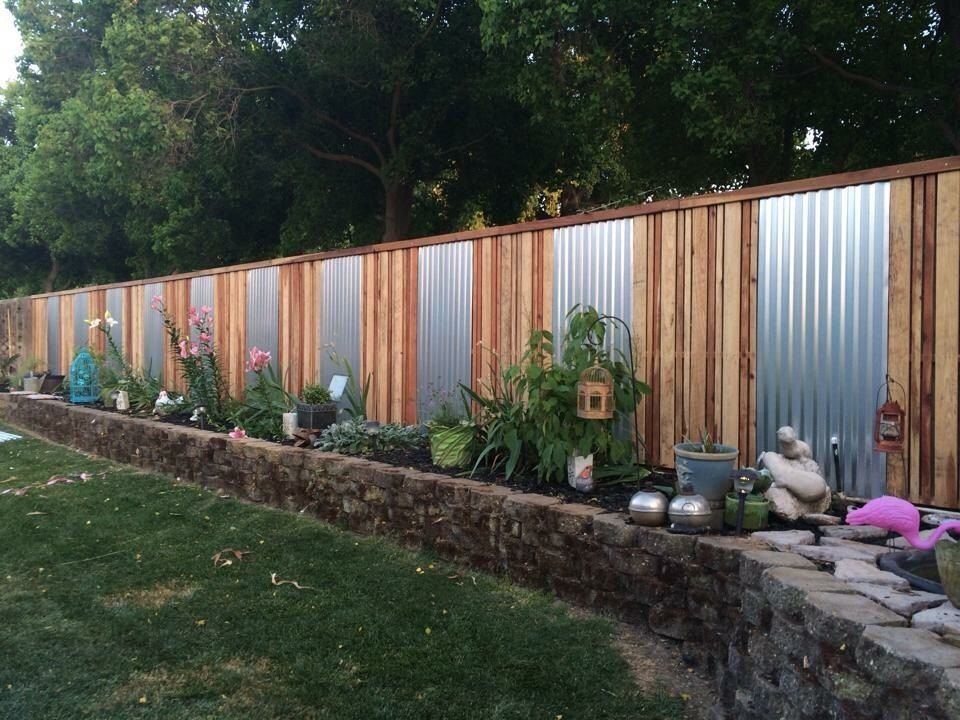 A wooden fence with a metal fence behind it
