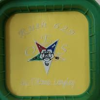 Green and yellow square plaque with a colorful star logo and Arabic text in the center