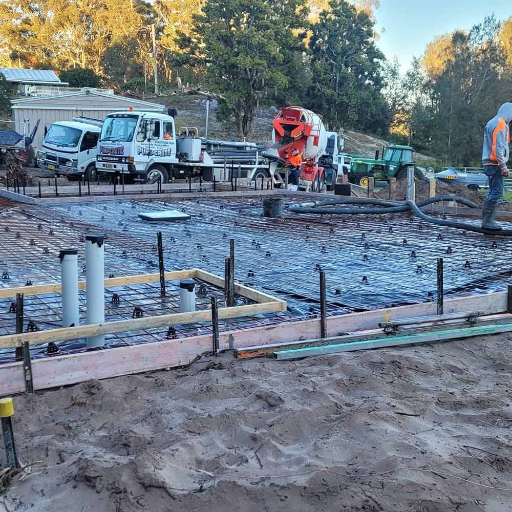 A Man is Standing in the Middle of a Construction Site — Dave Smith Concrete in Newcastle, NSW