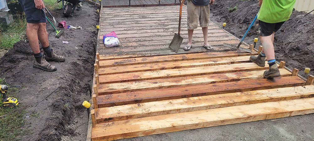 A Group of People Are Working on a Wooden Pallet — Dave Smith Concrete in Maitland, NSW