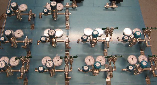 A bunch of gauges are lined up on a wall