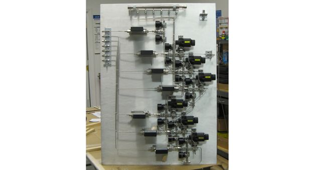A white board with a bunch of wires on it is sitting on a table.