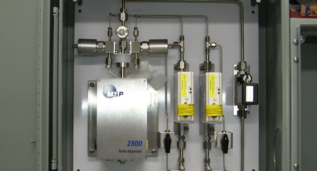 A stainless steel box with a valve and pipes inside of it.