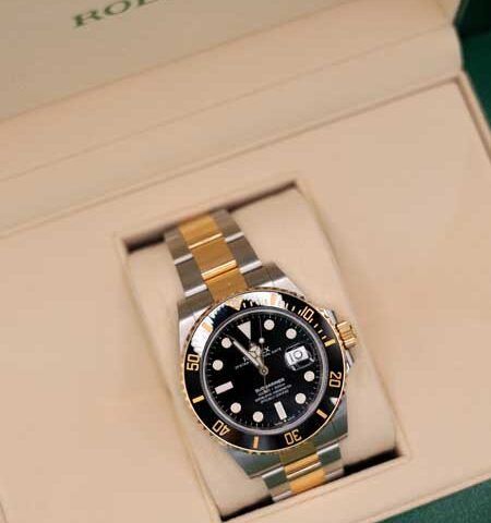 Two-tone Rolex watch with black dial in an open presentation box