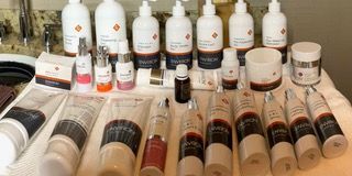 Assorted laboratory bottles and tubes arranged on a table, mostly white and clear containers with labels.