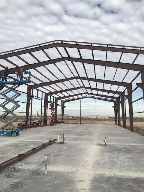 A large metal structure is being built in a field