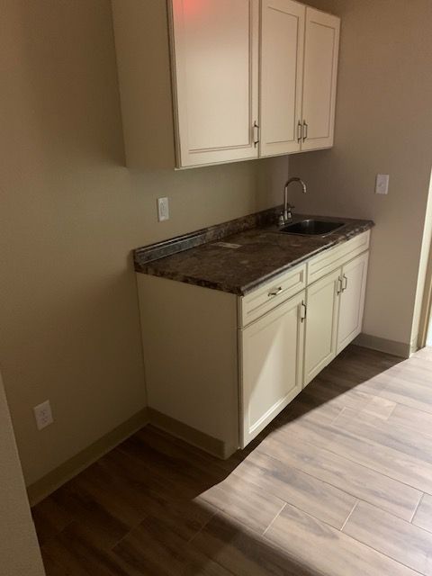 A kitchen with white cabinets and a sink.