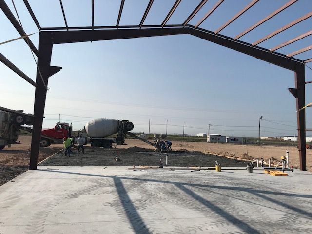 A concrete truck is pouring concrete into a building under construction