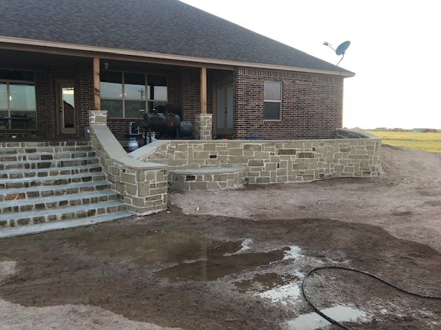 A brick house with a stone porch and stairs