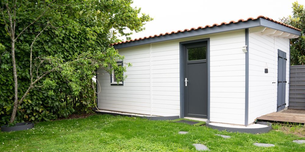 White Shed With Dark Gray Trim And Doors Sits On A Green Lawn — Ericson Constructions in Mareeba, QLD
