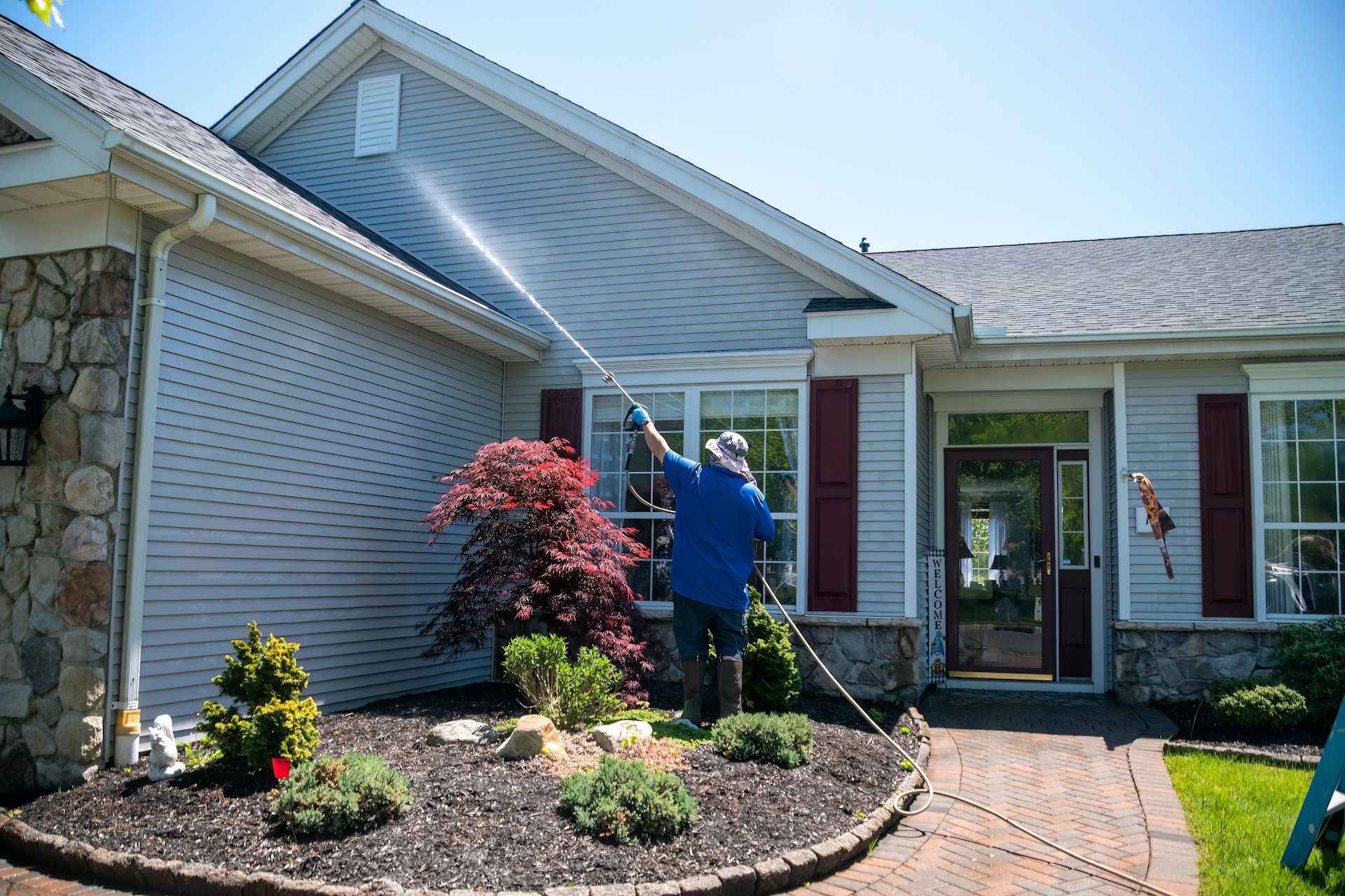 Person Power Washing a House Exterior — Ericson Constructions in Mareeba, QLD