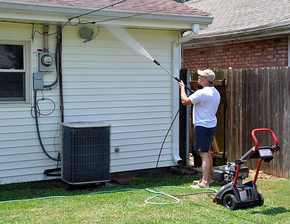 Man Power Washing a White House Exterior With a Pressure Washer — Ericson Constructions in Mareeba, QLD