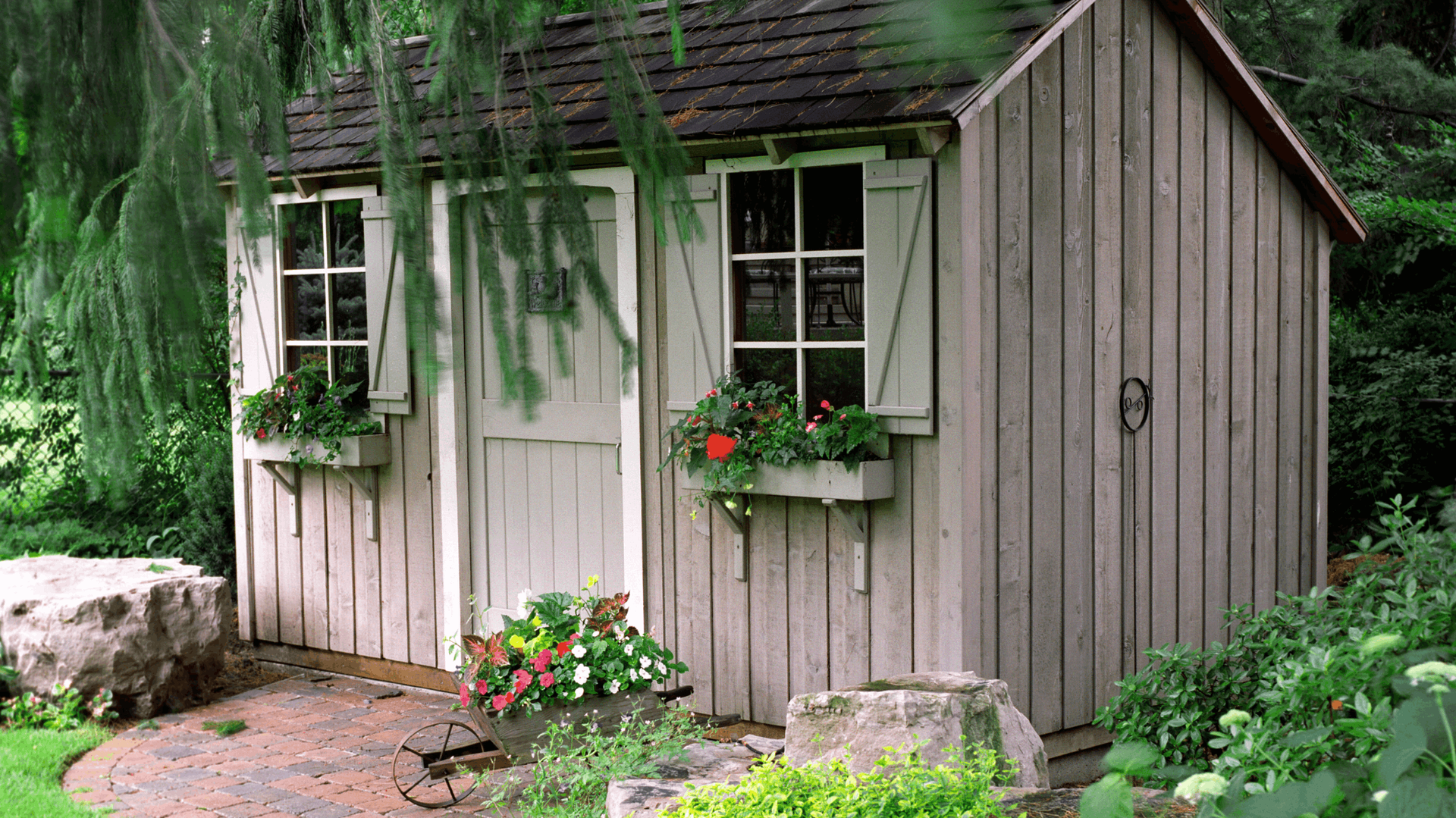 Wooden Shed With White Door, Window Boxes, and Shutters, Nestled in a Garden — Ericson Constructions in Mareeba, QLD