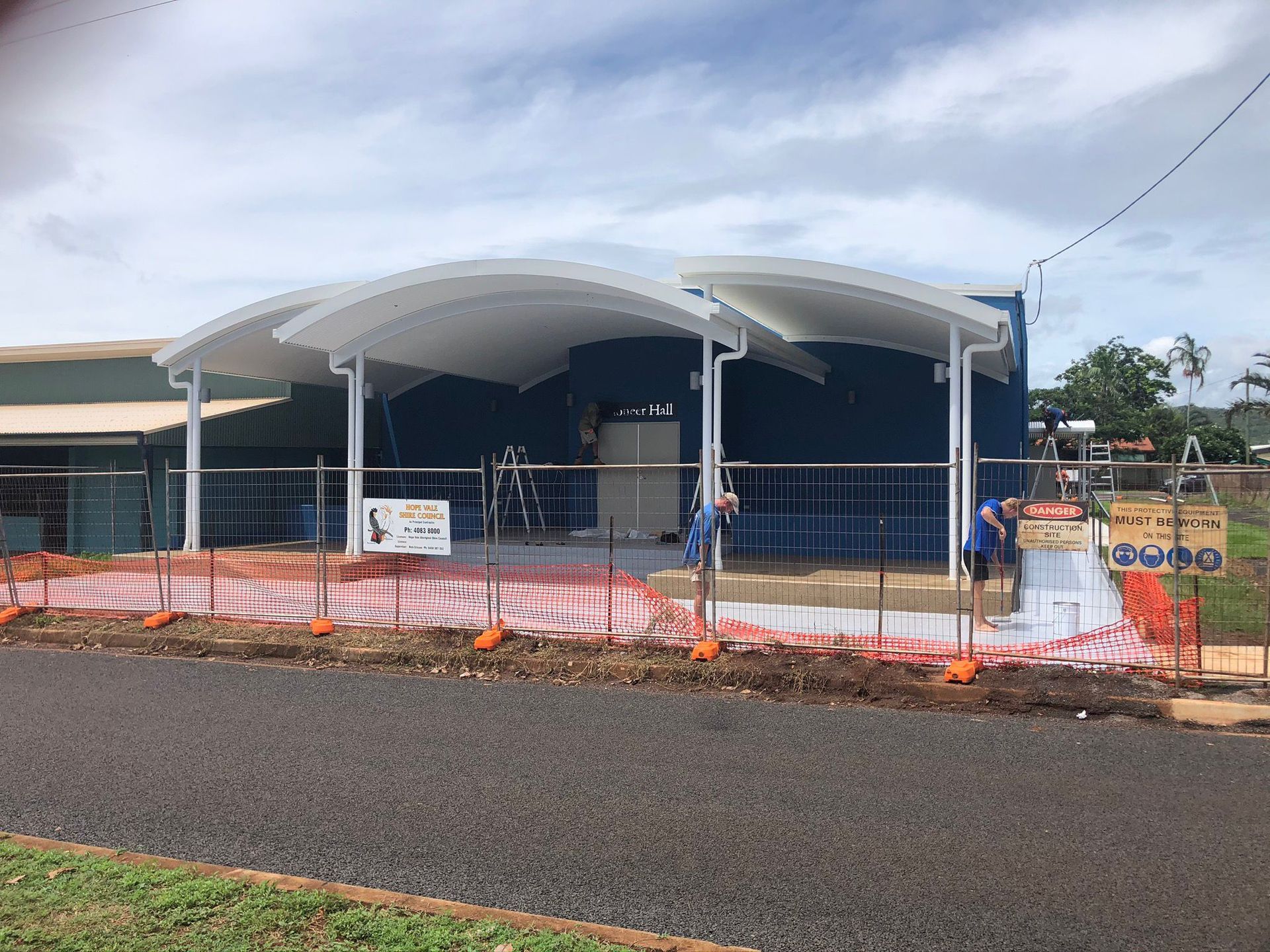 A Building Under Construction With a Blue Exterior and a White Arched Canopy — Ericson Constructions in Mareeba, QLD