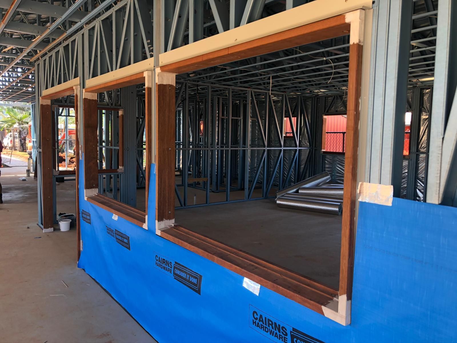 Construction Site With Wooden Window Frames Installed in Metal Framing — Ericson Constructions in Mareeba, QLD
